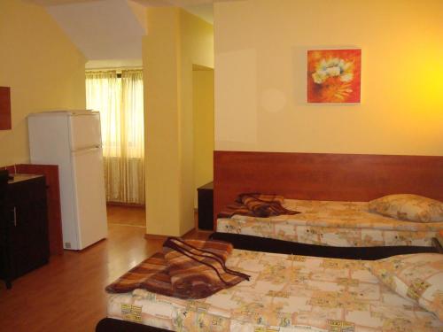 a hotel room with two beds and a refrigerator at Pensiunea Marc in Suceava