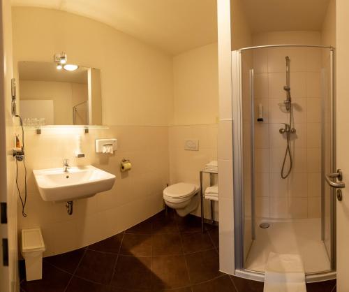 ein Bad mit einem Waschbecken, einer Dusche und einem WC in der Unterkunft Gästehaus Moser in Mönchhof