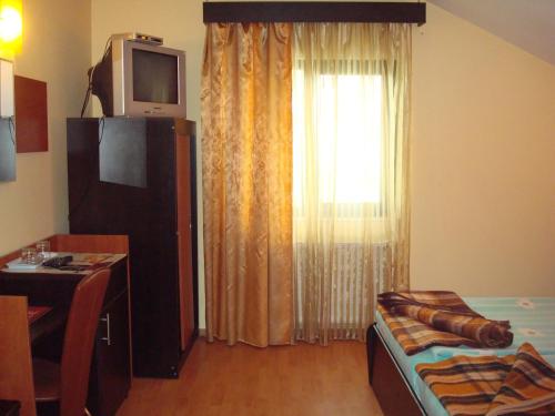 a living room with a tv on top of a window at Pensiunea Marc in Suceava