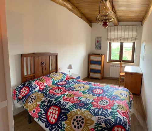 a bedroom with a bed with a colorful bedspread at El pajar de Miro in Villaturiel