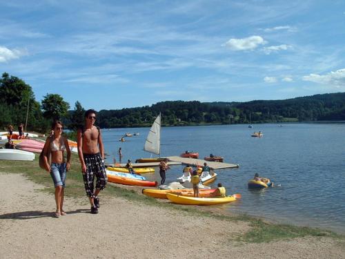 two people standing on the shore of a lake with boats at André et Viviane Chatelard - Chambres d'hôtes in Saint-Bonnet-le-Froid