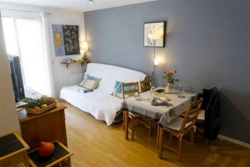 Habitación con cama y mesa con sillas. en Appartements dans Résidence de Luchon en Luchon