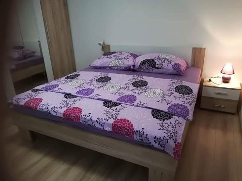 a bedroom with a bed with a purple comforter and pillows at Apartment Natali in Brseč