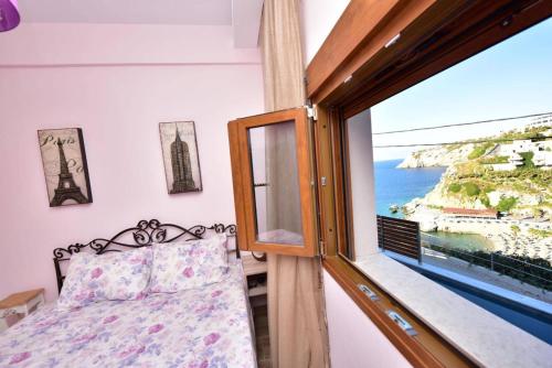a bedroom with a window with a view of the ocean at Sea Front Panorama Villa Private Pool in Agia Pelagia