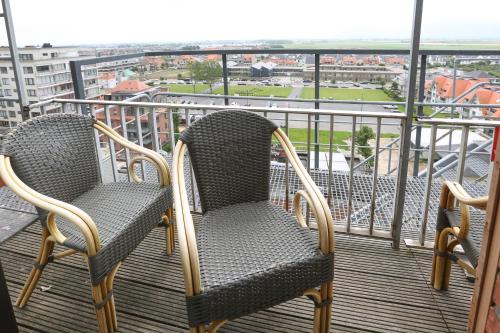 two chairs on a balcony with a view of a stadium at Hotel De Zeebries Budget in Middelkerke