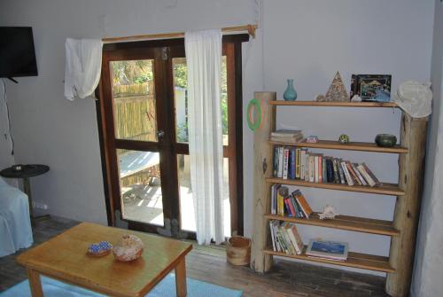 sala de estar con estante de libros y ventana en Ikaya Accommodation Psj en Port Saint Johnʼs