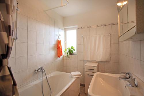 Un baño blanco con bañera y lavabo. en Landhaus Hinterebenhub, en Hopfgarten im Brixental