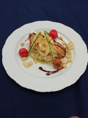 a white plate with food on a blue table at Pension und Restaurant Gutshaus Kaltenhof in Kaltenhof