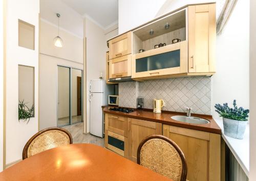 a kitchen with wooden cabinets and a table with chairs at Квартира на Пушкінській in Kyiv