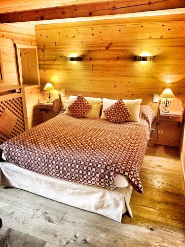 une chambre avec un lit dans une pièce en bois dans l'établissement Chalet Marie Claire, à Notre-Dame-de-Bellecombe
