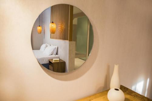 a bedroom with a mirror and a bed and a vase at Calmare suites in Rethymno Town
