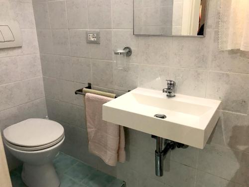 a bathroom with a white sink and a toilet at Casa al Castello in Isola del Giglio