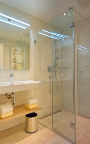 a bathroom with a glass shower and a sink at Appartementhotel Fidelio in Bad Füssing