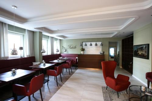 a dining room with tables and red chairs at Appartementhotel Fidelio in Bad Füssing
