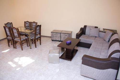 a living room with a couch and a table and chairs at Red Hotel Yerevan Center in Yerevan