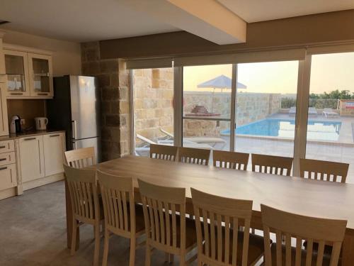 uma cozinha com mesa e cadeiras e uma piscina em Villa Chossie em Żejtun