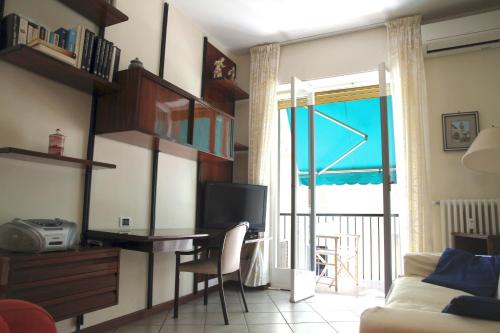 ein Wohnzimmer mit einem Schreibtisch, einem TV und einem Sofa in der Unterkunft Delizia apartment in Rapallo