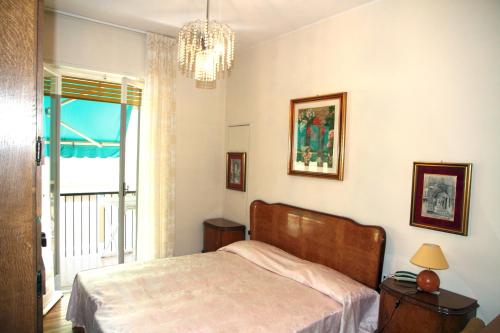 a bedroom with a bed and a window and a chandelier at Delizia apartment in Rapallo