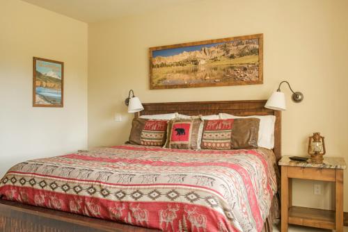a bedroom with a bed with a red comforter at Hoos Views in Big Sky Mountain Village