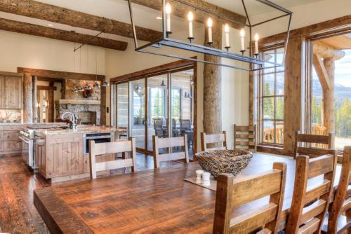 a dining room with a table and a kitchen with wood floors at Hoos Views in Big Sky Mountain Village