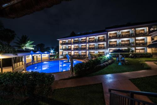 un complejo con piscina por la noche en Dolphin Suites en Kampala