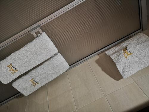 two towels are hanging on a door in a bathroom at Hotel Royal Suite in Manizales