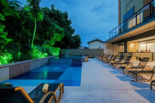 a row of chairs sitting next to a swimming pool at Guarujá Vivah in Guarujá