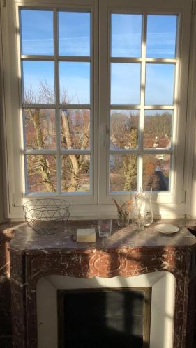 - une cheminée dans une chambre avec 2 fenêtres dans l'établissement Napoleon Chateau Luxuryapartment for 18 guests with Pool near Paris!, à Saint-Jean-aux-Bois