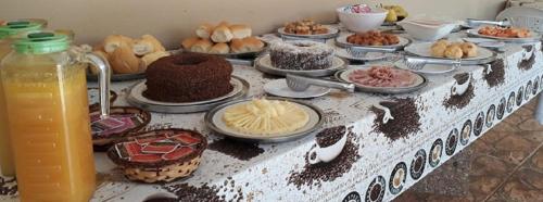 een tafel met veel verschillende soorten voedsel erop bij Pousada Aldeia das Flores in Olímpia