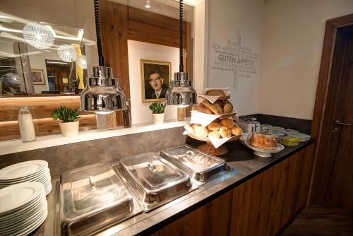 a kitchen with a counter top with bread and dishes at Hotel zur Post in Sankt Valentin