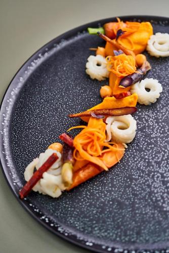 a black plate with some food on it at Maison Nô - Hôtel et Rooftop in Lyon