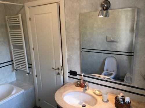 a bathroom with a sink and a toilet with a mirror at Villa LIDSON in Golem