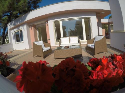 a patio with two chairs and red flowers at Villa LIDSON in Golem