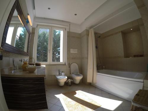 a bathroom with a tub and a toilet and a sink at Villa LIDSON in Golem