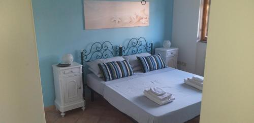 une chambre bleue avec un lit et 2 tables de chevet dans l'établissement Appartamento vista mare, 100mt dall'Ospedale Pediatrico, a 200mt dal mare, 1h da Roma Termini, à Santa Marinella