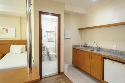 a bathroom with a bed and a sink and a toilet at Hotel The Premium in Osasco