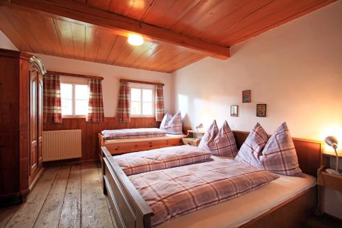 1 Schlafzimmer mit 2 Betten in einem Zimmer mit Holzdecken in der Unterkunft Ferienhaus Hinterebenhub in Hopfgarten im Brixental