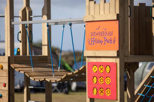 a sign on a playground swinging bench at Newperran Holiday Park in Newquay