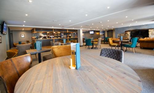 a table in a restaurant with chairs and a bar at Newperran Holiday Park in Newquay