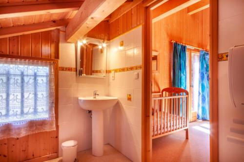 een badkamer met een wastafel en een kinderbedje bij Chalet Clairvaux in Montriond