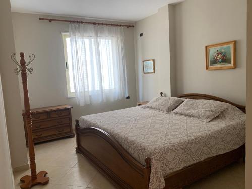 - une chambre avec un lit, une commode et une fenêtre dans l'établissement Beachfront apartment Ridi, à Durrës