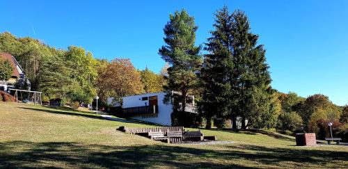 a group of benches in a park with trees at Berg-Bungalows Leinleitertal in Heiligenstadt