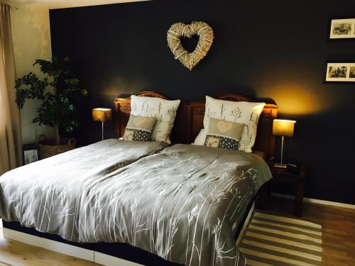 a bedroom with a bed with a heart on the wall at Gästehaus Sellemols Ferienwohnung Korbmacher in Heuchelheim-Klingen