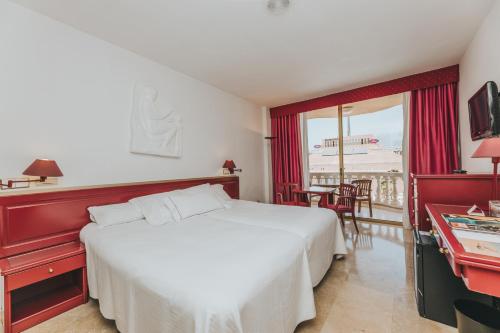 a hotel room with a white bed and a balcony at Hotel Cleopatra Palace in Playa de las Americas