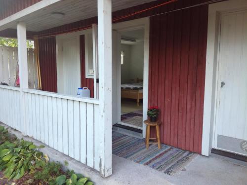 an open door of a red house with a porch at Guesthouse Lokinlaulu in Kotka