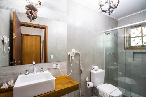 a bathroom with a toilet a sink and a bathtub at Pousada Da Pedra in Campos do Jordão