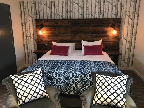 a bedroom with a large bed with red pillows at The Crown, Hutton le Hole in Hutton le Hole