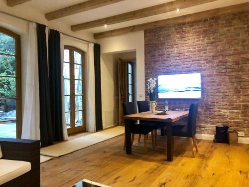 una sala da pranzo con tavolo e muro di mattoni di Villa Erica a Teltow