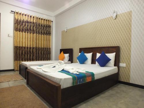a bedroom with a bed with towels on it at Buddika Safari & Resort in Udawalawe
