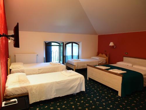 a hotel room with three beds and two beds sidx sidx sidx at Hotel Parco Fola in Albinea